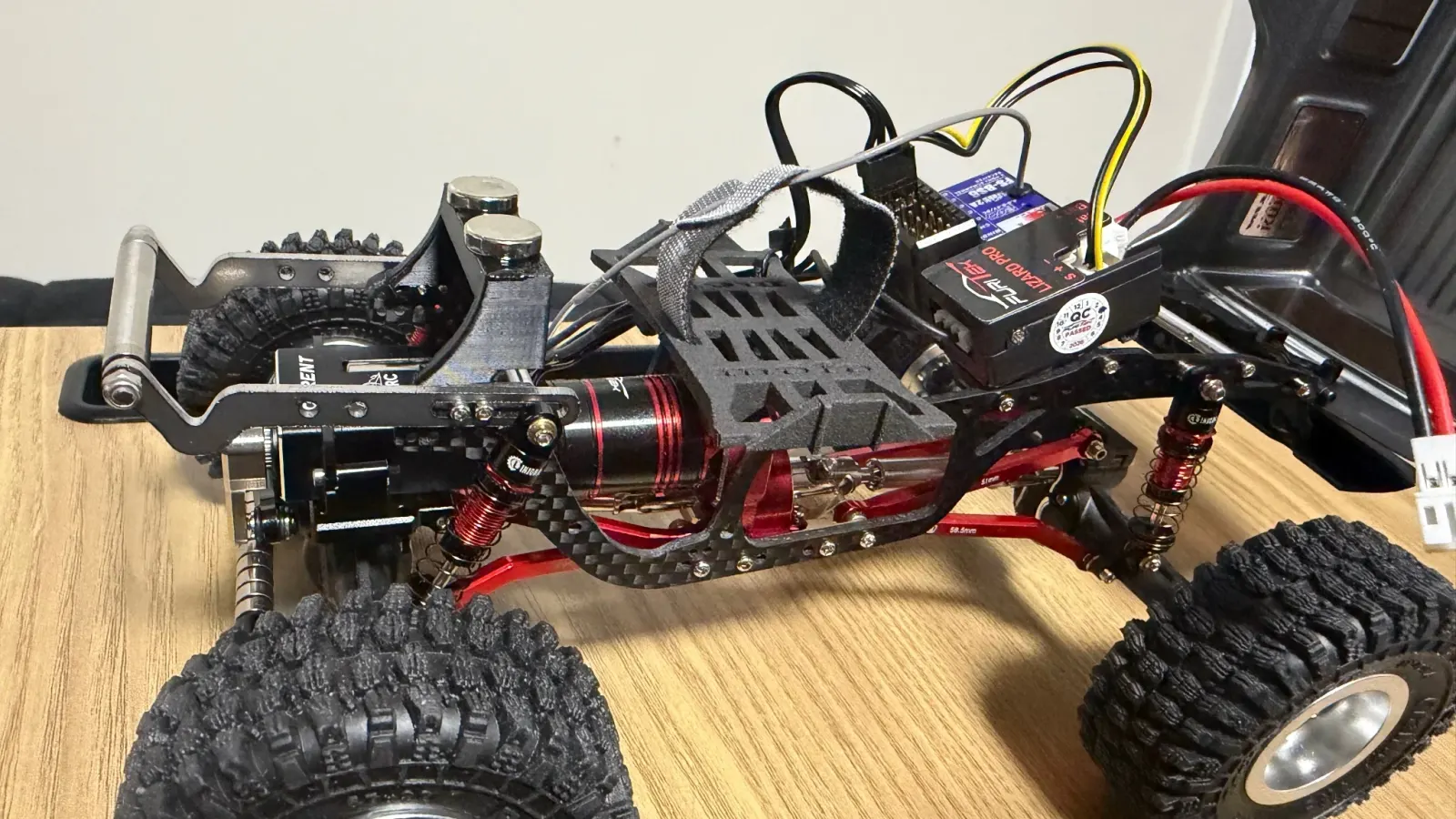 SCX24 chassis with a carbon battery tray and strap above the motor