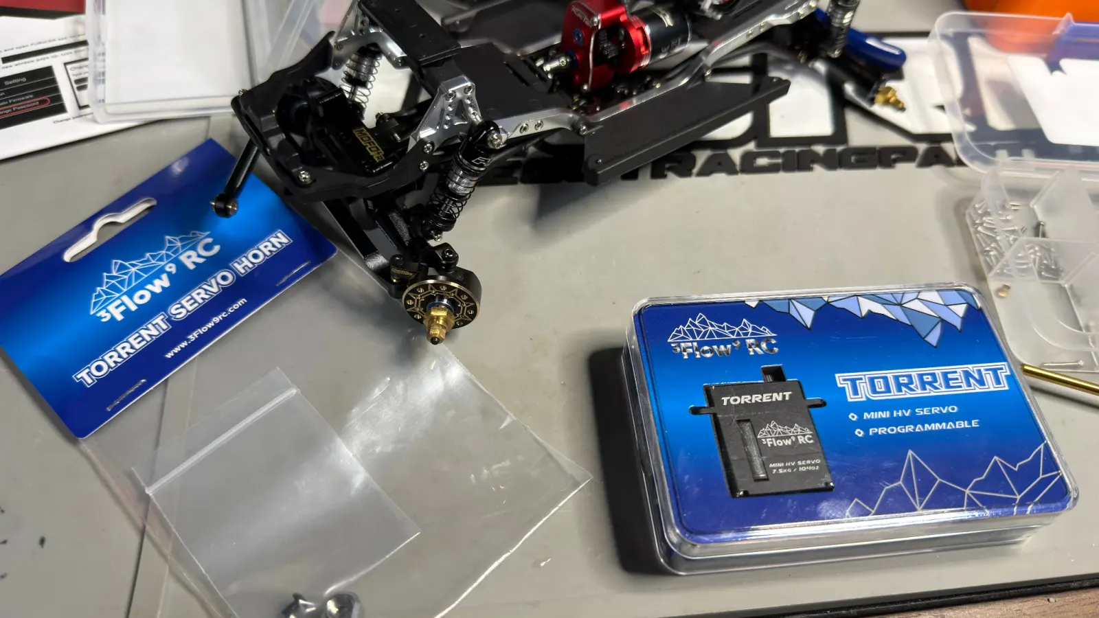 A Flow RC Torrent servo and servo horn in their packaging