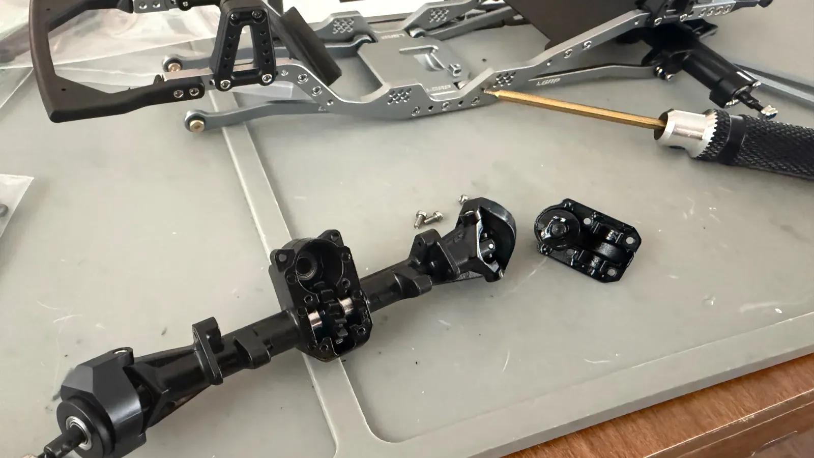 An SCX24 axle housing apart next to its parts during a rebuild