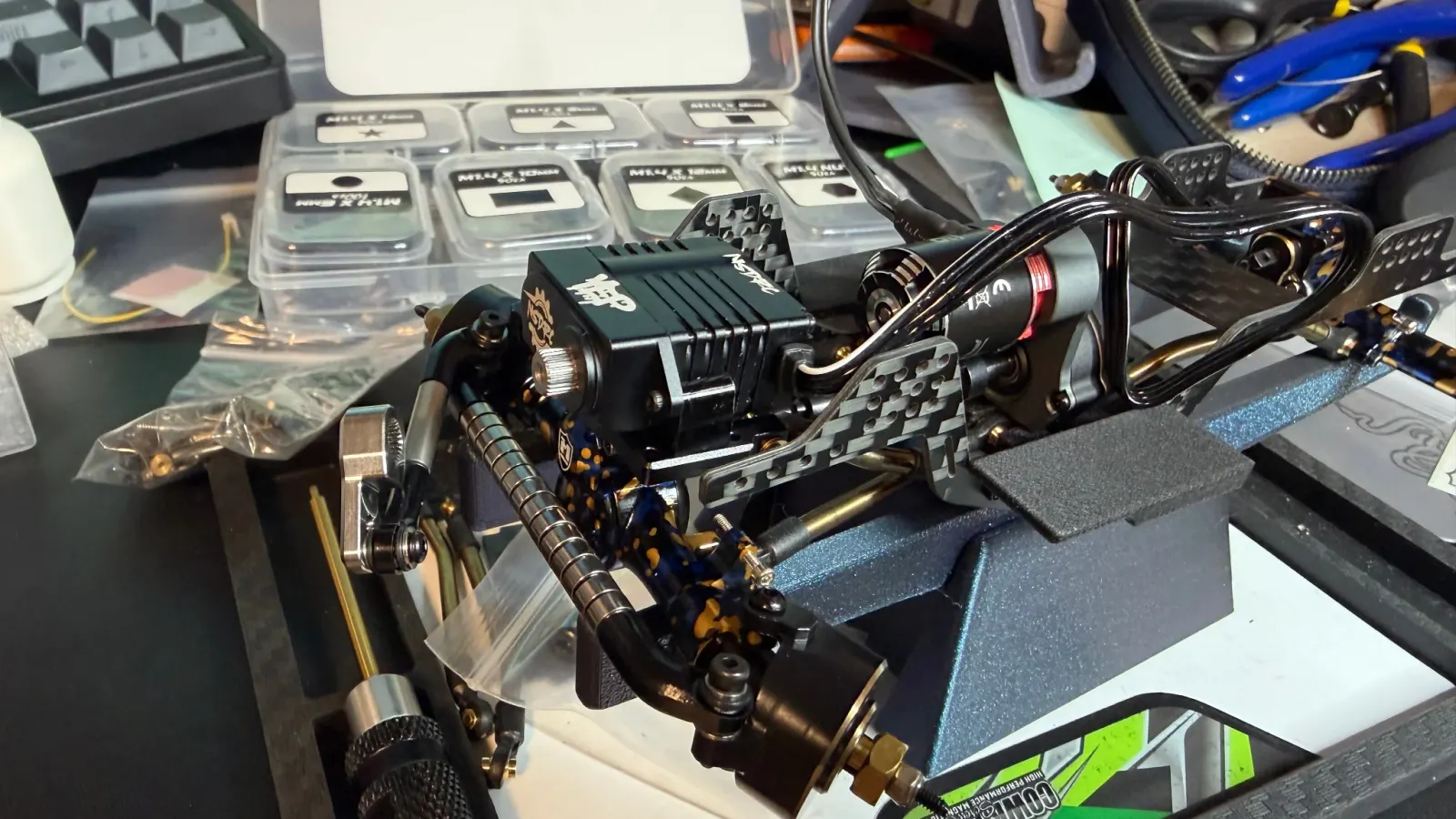 SCX24 chassis on a stand surrounded by organized hardware