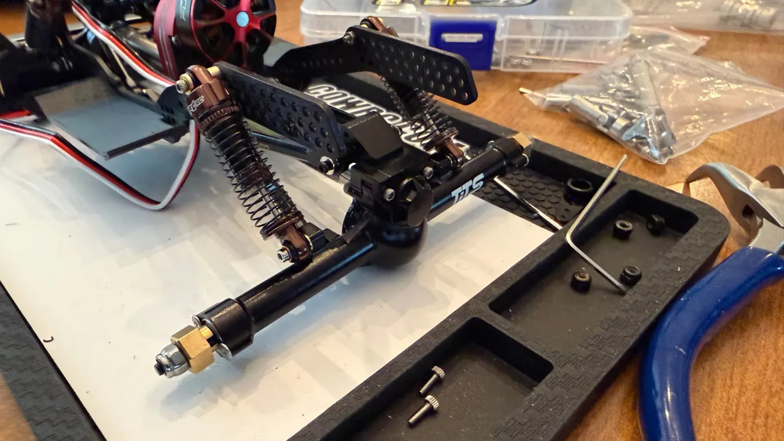 An oil shock and axle being assembled on a work mat