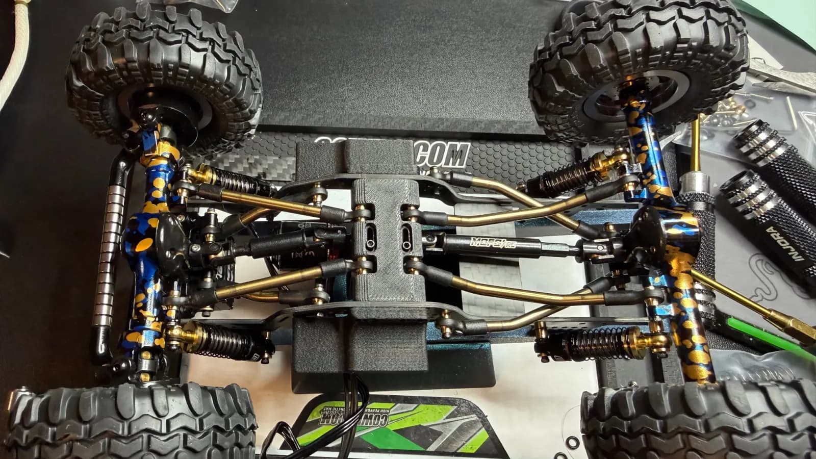 Top view of a rolling chassis with gold oil shocks and brass links