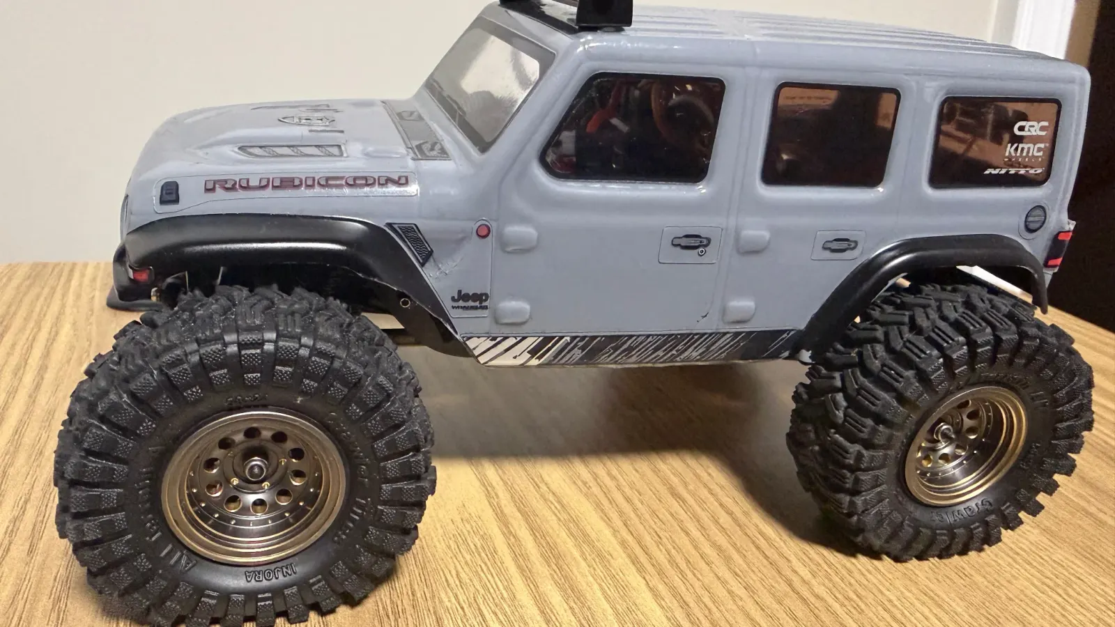 A gray JLU on its stock style wheels, the starting point for upgrades